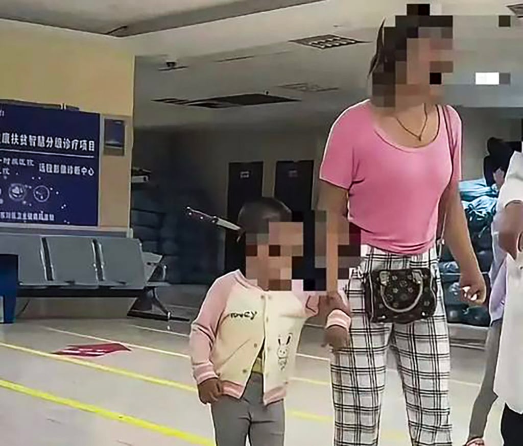 Hu walks into the hospital with her toddler daughter, who has a fruit knife stuck into the side of her head. Photo: Weibo