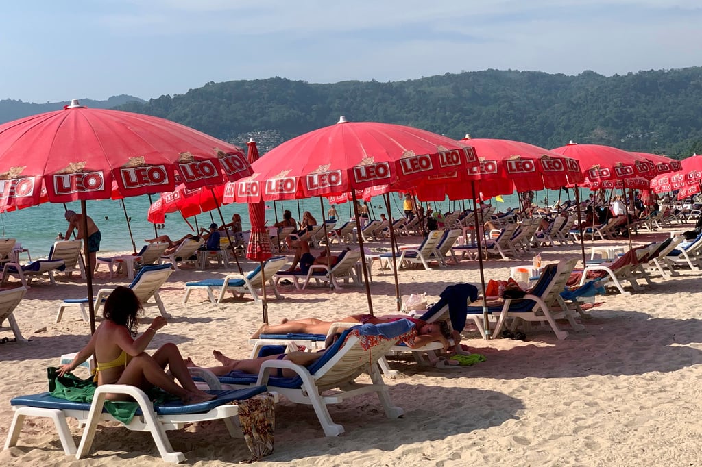 Tourists lounge under umbrellas along Patong Beach in Phuket. Local authorities have launched public awareness campaigns to urge tourists to obey warnings and swim only in patrolled areas. Photo: AP