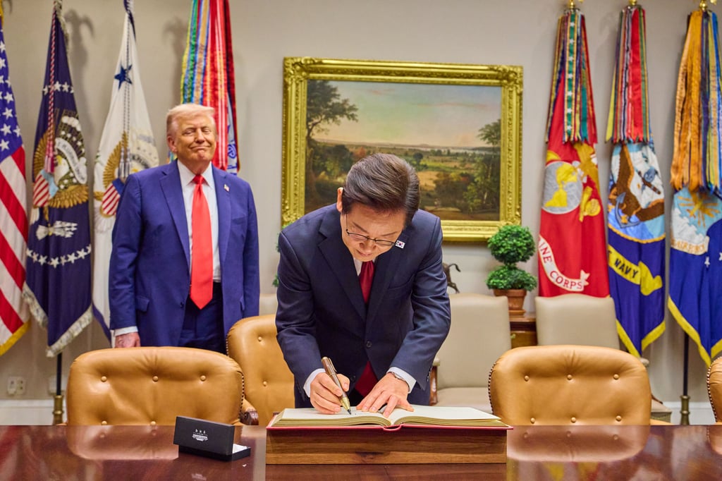 South Korea’s President Lee Jae-myung signs the guest book at the White House in front of US President Donald Trump. Photo: dpa