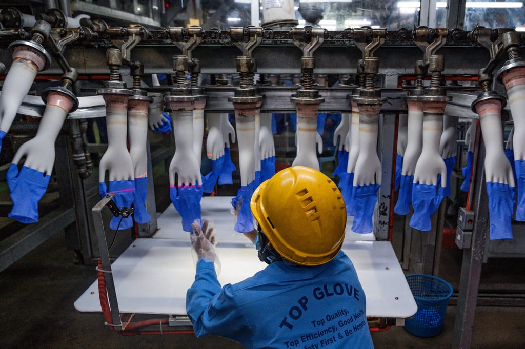 A worker inspects disposable gloves at the Top Glove factory on the outskirts of Kuala Lumpur. Lau’s family fortune is tied to the world’s largest rubber glove manufacturer. Photo: AFP