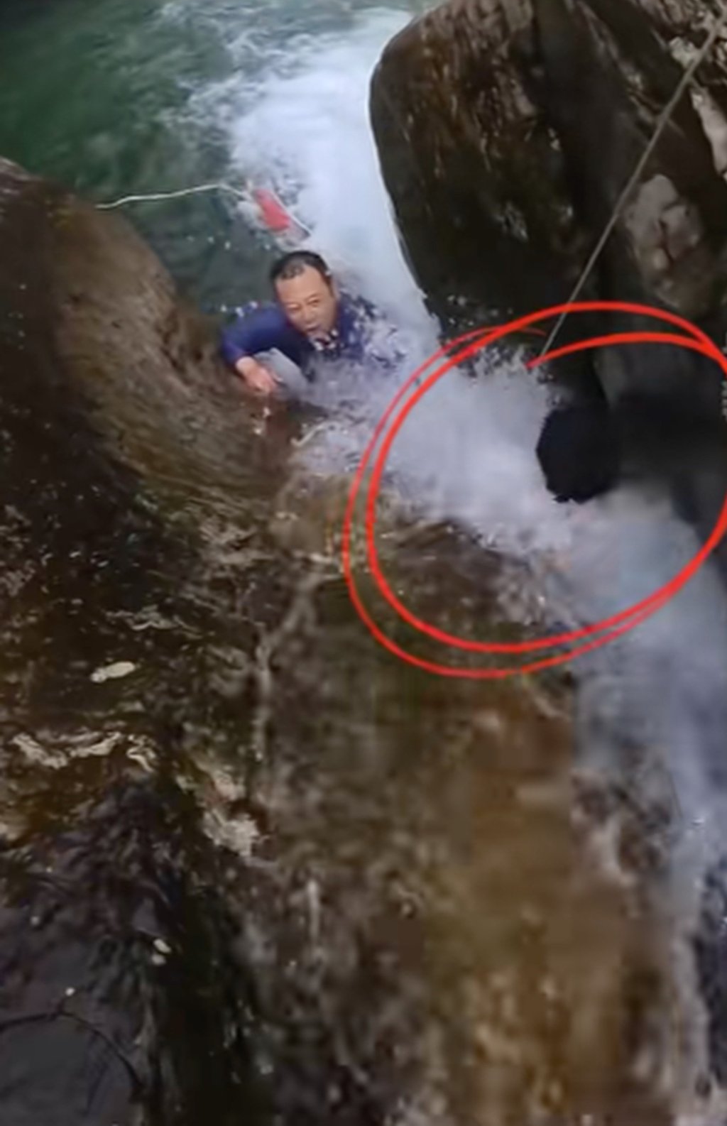 The youngster became trapped between two huge rocks as the rapids surged around him. Photo: Douyin
