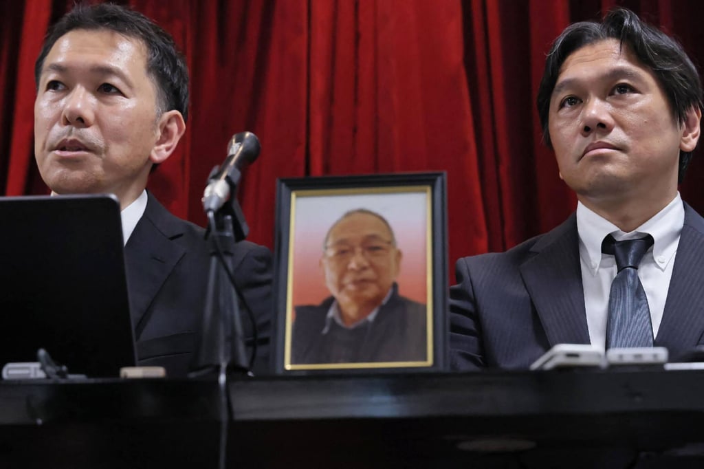 A portrait of the late Shizuo Aishima is displayed between his sons during a press conference in Yokohama on Monday. Photo: AFP