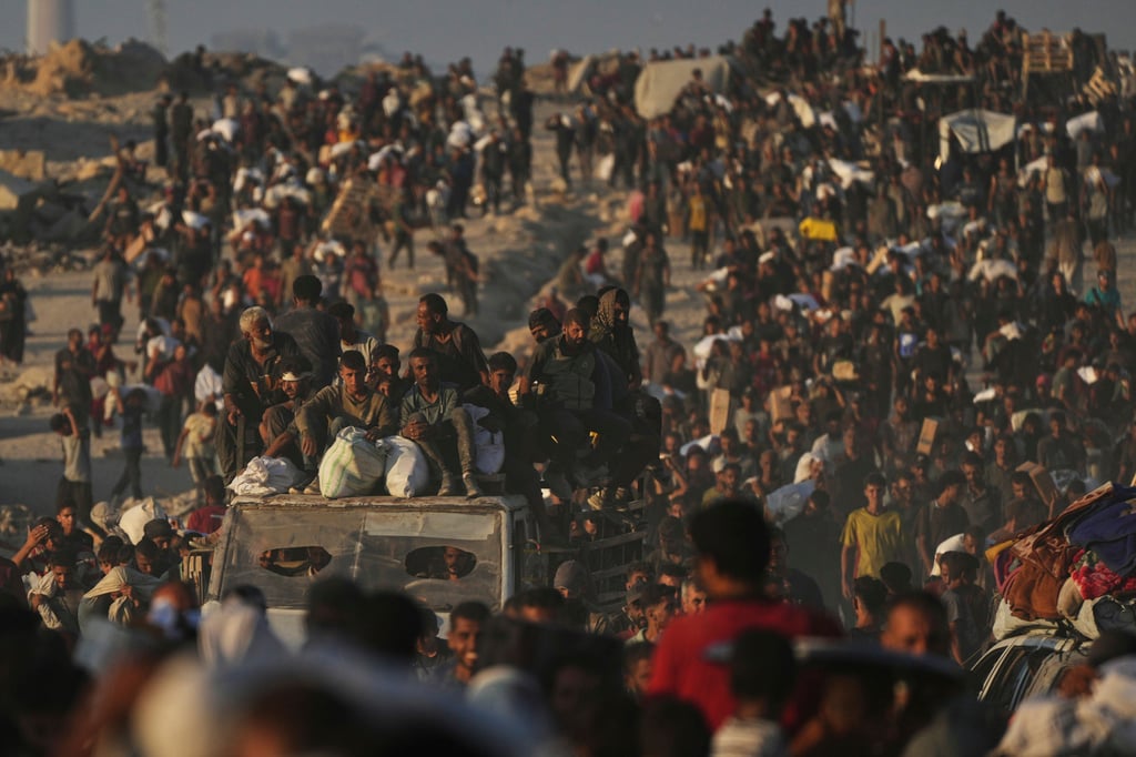 Palestinians carry sacks of flour unloaded from a humanitarian aid convoy. Photo: AP
