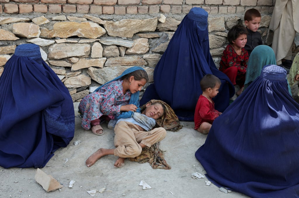 A girl takes care of her brother. Photo: Reuters
