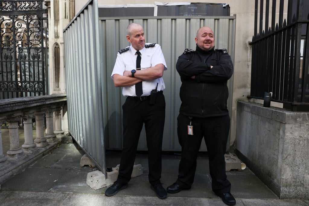 Security guards stand in front a screen covering the mural on Monday. Photo: Reuters