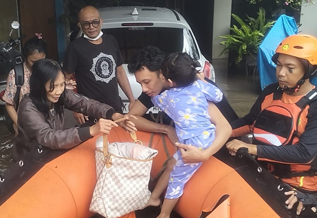 Rescuers evacuate people from a flooded residential area after heavy rain in Denpasar on Wednesday. Photo: Basarnas/Xinhua