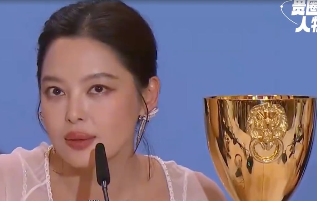 Xin Zhilei speaks to the media alongside the best actress award trophy she won at this year’s Venice Film Festival. Photo: Sina