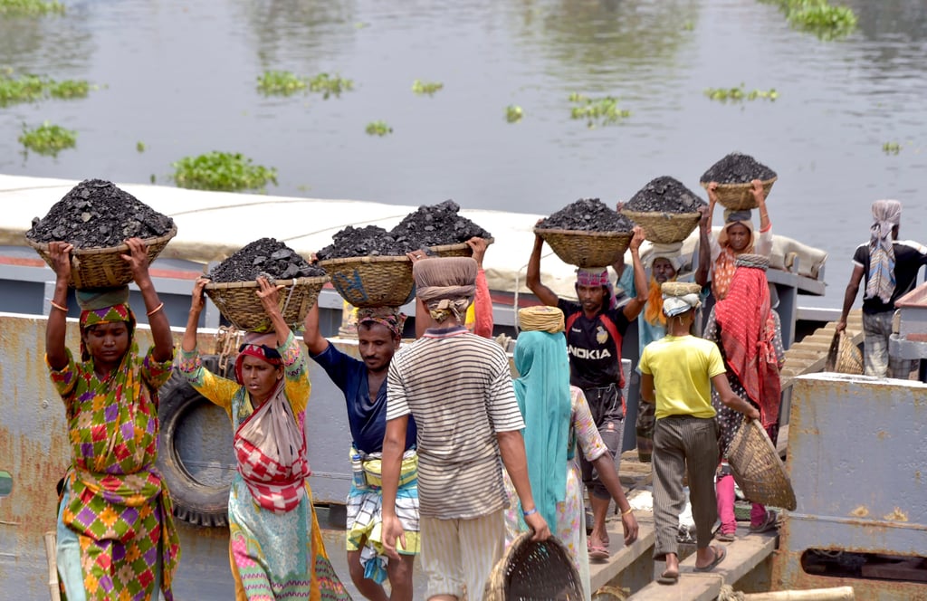 Labourers unload coal from a ship at a riverbank bank in Dhaka. Power imports, mainly from an Adani Power-run coal-fired plant in eastern India, have helped satisfy most of the rising electricity demand in Bangladesh. Photo: Xinhua