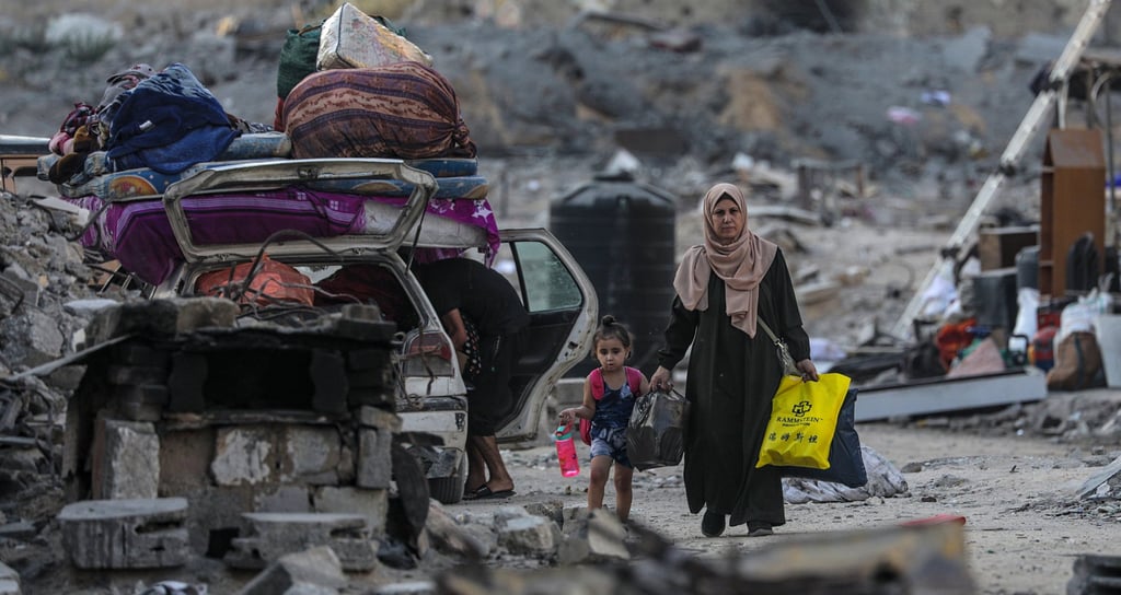 Palestinians evacuate an area targeted by an Israeli air strike in Gaza City on Sunday. Photo: EPA