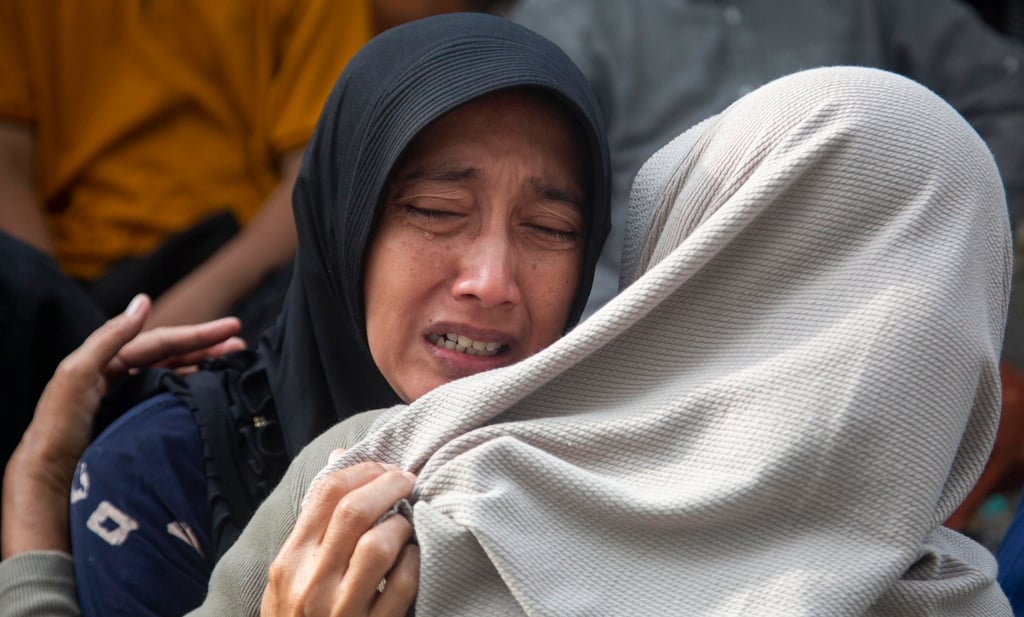 Relatives comfort each other as a rescue operation continues on Tuesday after a building collapsed at an Islamic boarding school in Sidoarjo, East Java, Indonesia. Photo: EPA