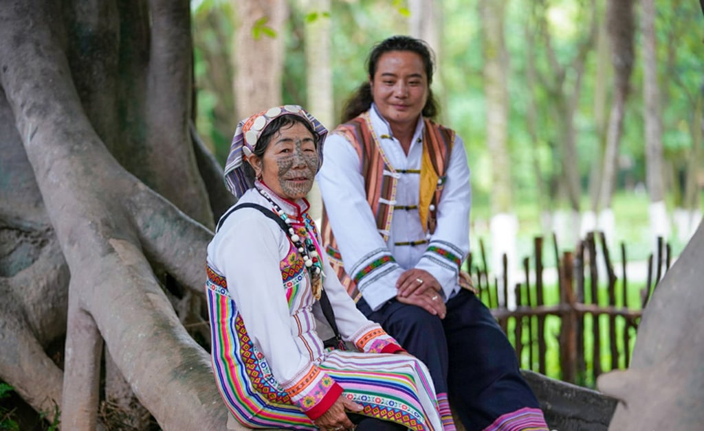 Two ethnic Derung women relax beneath a tree in their village in southwestern China. Photo: Handout