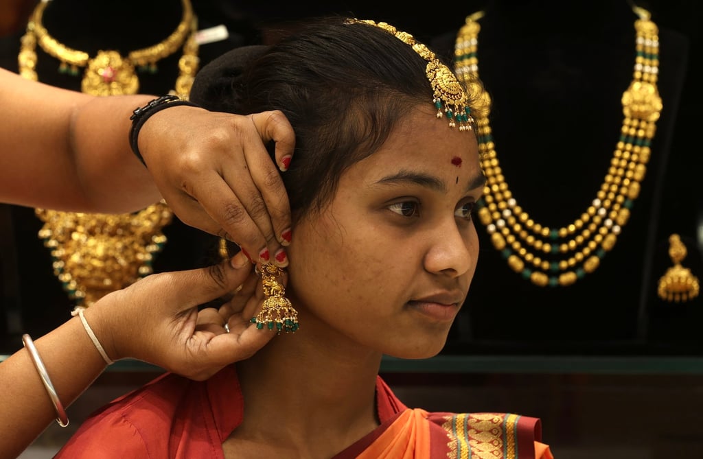 An Indian woman tries on gold ornaments at a jewellery shop in Bengaluru, India, on Monday. Photo: EPA