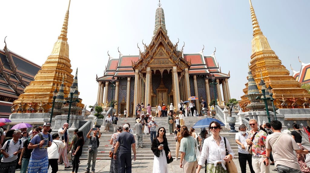 Foreign tourists visit the Temple of the Emerald Buddha at the Grand Palace complex in Bangkok. The country expects an almost 6 per cent drop in foreign arrivals. Photo: EPA