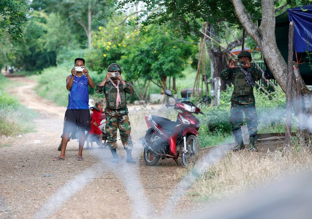 Cambodian soldiers and settlers photograph and film Thai soldiers and the Interim Observer Team members in Ban Nong Ya Kaew, Sa Kaeo province, Thailand, on October 10. Photo: EPA