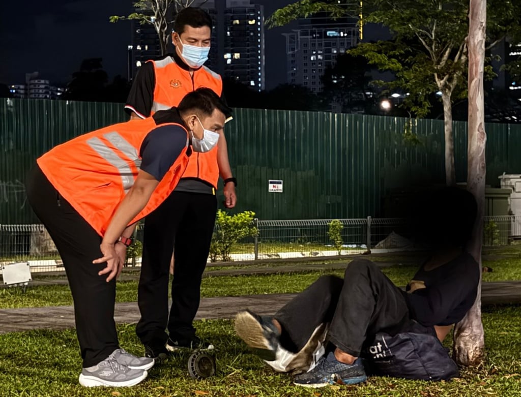 Malaysian authorities talk to a homeless man in Kuala Lumpur on Thursday. Photo: Facebook/Department of Federal Territories