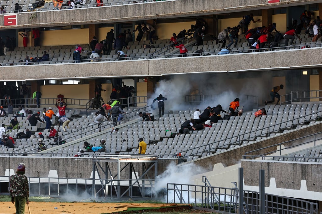 People flee as tear gas is released inside Kasarani Stadium in Nairobi, Kenya, on Thursday. Photo: EPA