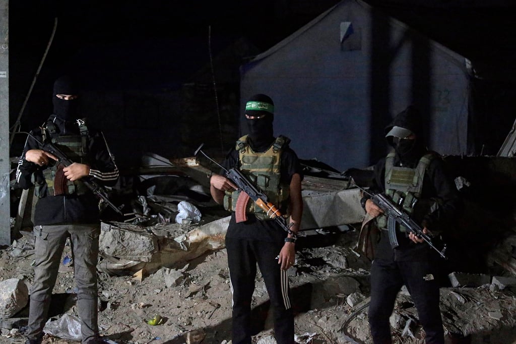 Hamas fighters guard as Red Cross vehicles arrive in Gaza City to transport remains of Israeli hostages. Photo: EPA
