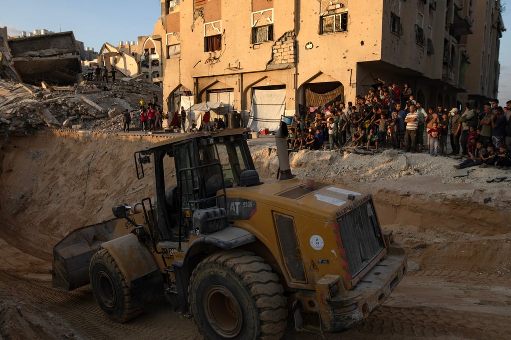 Locals gather to watch as an excavator works at the site where Hamas members are searching for the bodies of Israeli hostages in Khan Younis, in the southern Gaza Strip, on Friday. Photo: EPA