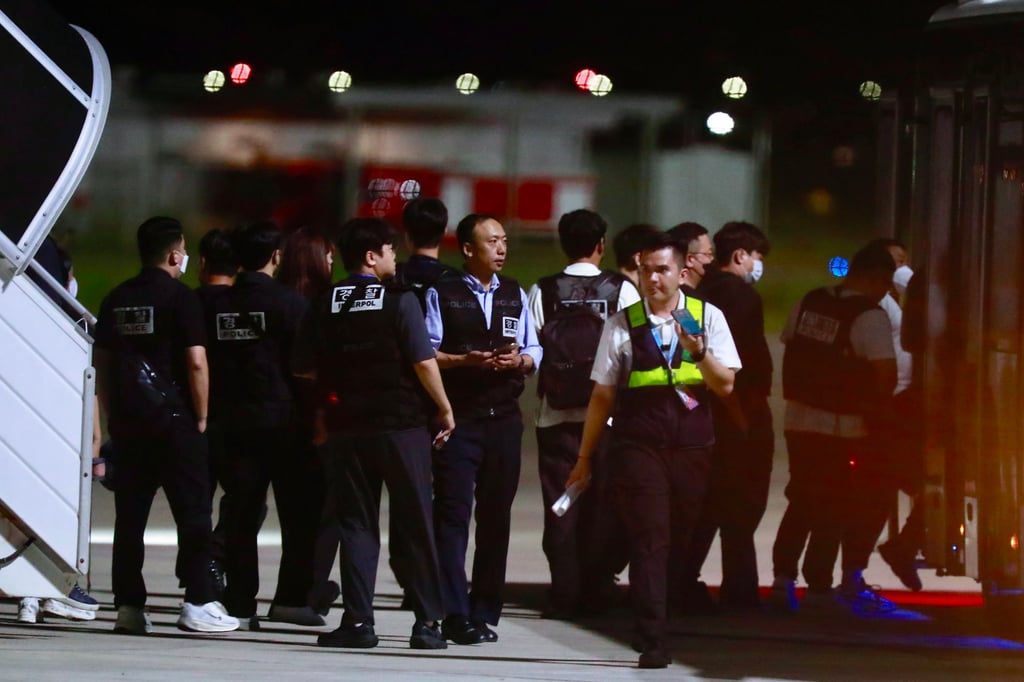 South Korean police officers walk at Techo International Airport near Phnom Penh on Friday night. Photo: EPA