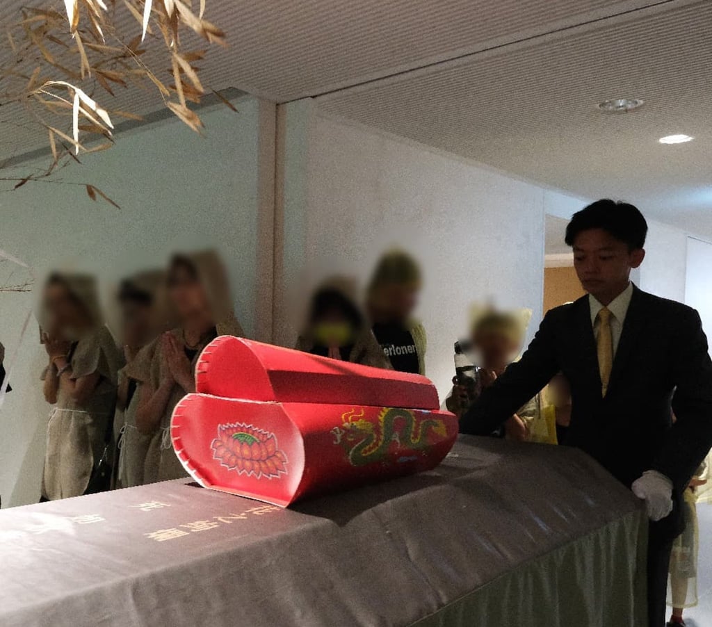 A miniature paper coffin is placed on top of a real coffin at a funeral ceremony before it is burned alongside to prevent further deaths in the family. Photo: sunshines.com.tw