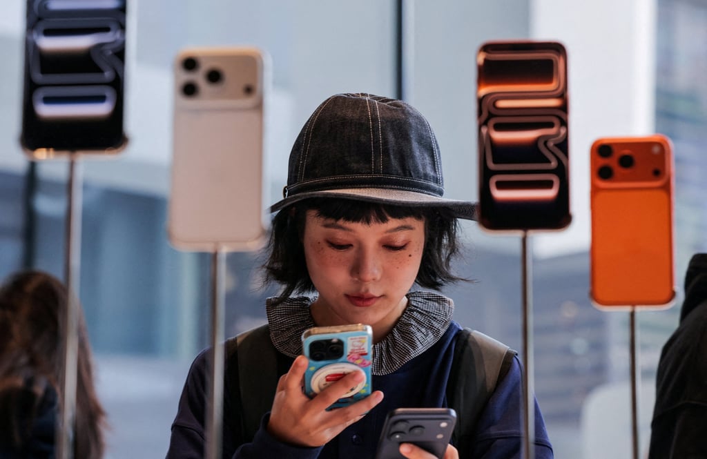 A woman uses her smartphone inside the Apple Store in Beijing’s Sanlitun area, as the new iPhone 17 series handsets go on sale on September 19, 2025. Photo: Reuters