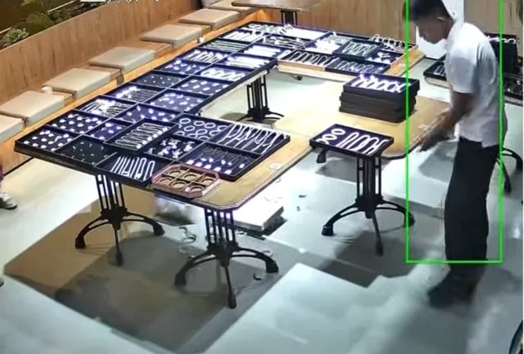 While moving a table, the clerk, above, accidentally knocked over a box of jade bangles, causing a loud crash. Photo: Douyin