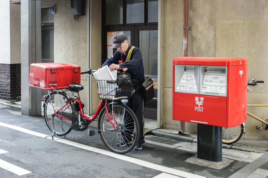 A Japanese postman sorts mail near a postbox. Japan issued guidelines in 2022 covering human rights in the workplace. Photo: Shutterstock