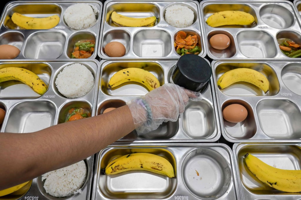 A government worker prepares meals for primary and middle school students in Jakarta. Photo: AFP