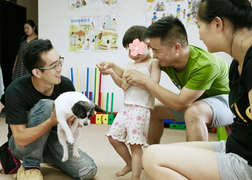 Wu Qi, far left, who is known as “the father of China’s therapy dogs”, chats with some of the people he helps. Photo: ycwb.com