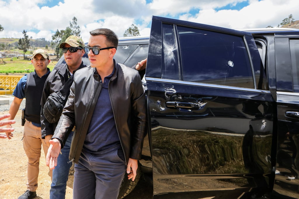 Ecuador’s President Daniel Noboa next to a car showing signs of damage after his motorcade was attacked by a crowd throwing rocks. Photo: Ecuador Presidency via Reuters