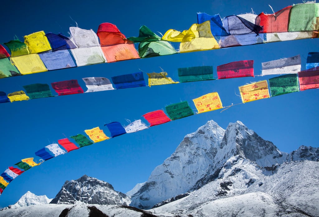 Colourful Buddhist prayer flags wave above Ama Dablam. Photo: Getty Images