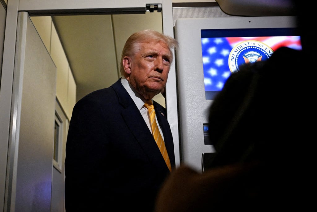 US President Donald Trump talks to members of the press on board Air Force One en route to Florida on Friday. Photo: Reuters