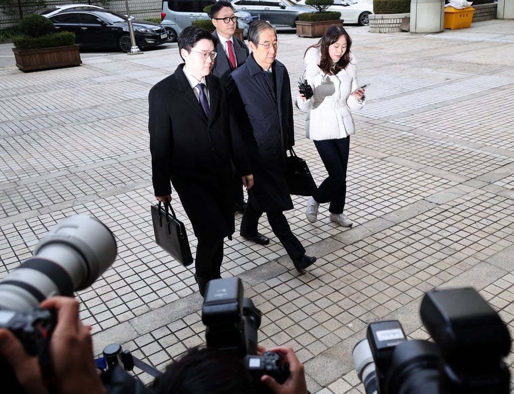 Former prime minister Han Duck-soo (centre) arrives for the closing hearing of his case at the Seoul Central District Court on Wednesday. Photo: Reuters