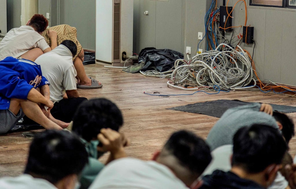 Alleged scam centre workers and victims sit next to dismantled IT and electronic appliances during a crackdown in Shwe Kokko on February 18. Photo: AFP