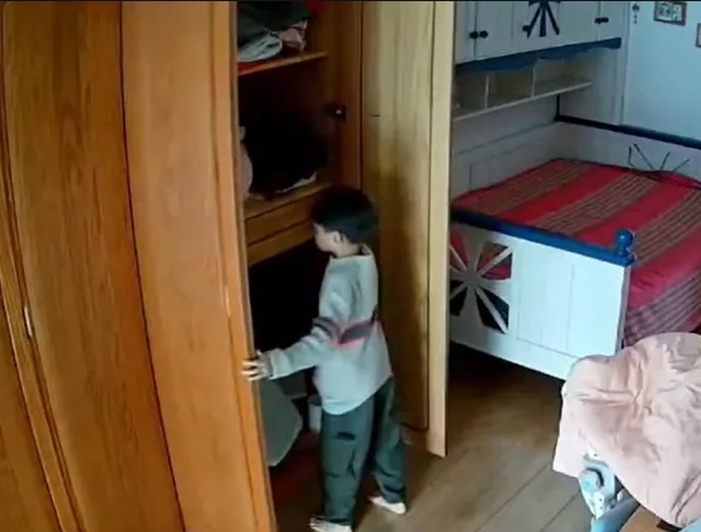 Household video footage shows the youngster looking in a cupboard. Photo: QQ.com