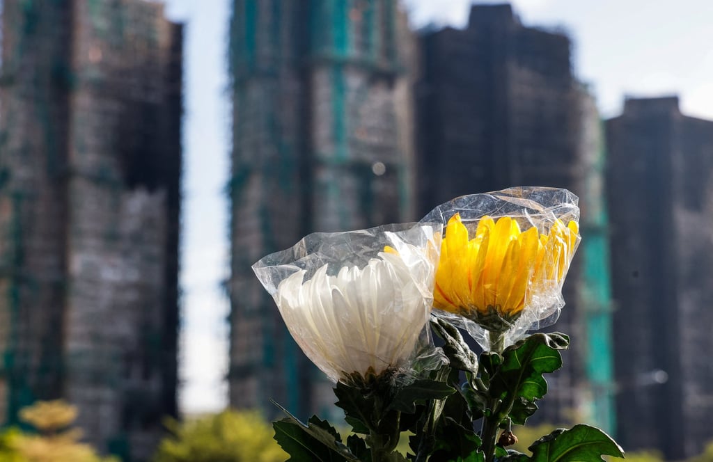 Flowers are seen next to the buildings at Wang Fuk Court in Tai Po on Tuesday after last week’s deadly fire. Photo: Reuters