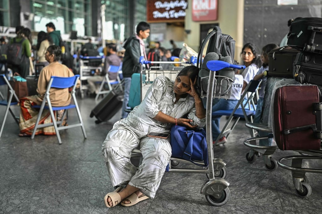 A passenger waits outside the IndiGo Airlines kiosk at the Kempegowda International Airport in Bengaluru on Saturday, as the IndiGo crisis enters a fifth day. Photo: AFP