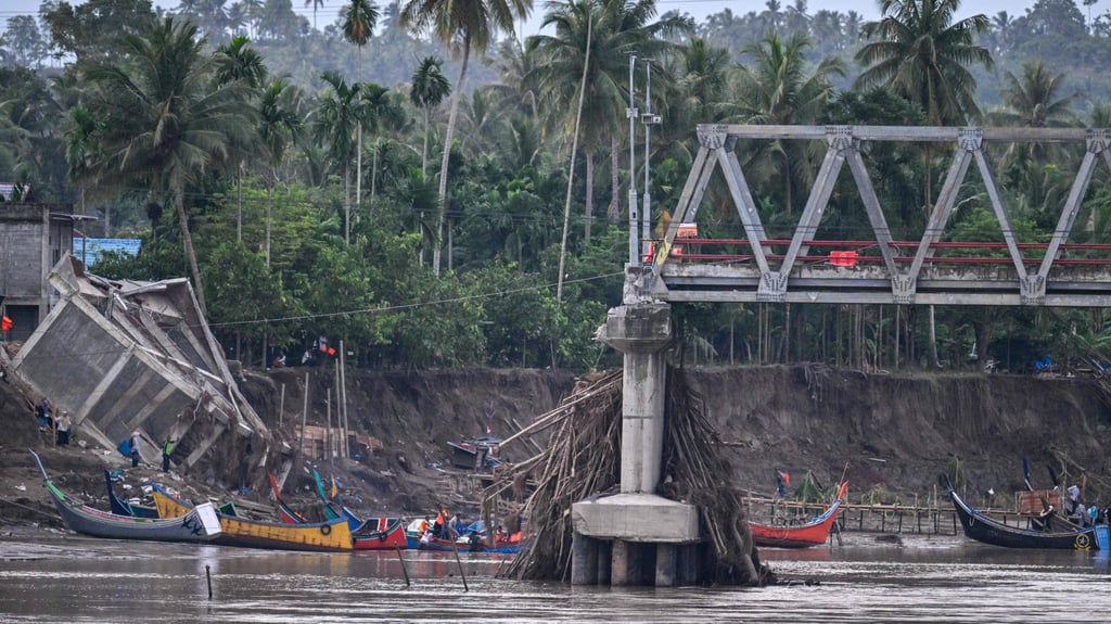 Boats are used to ferry passengers across the Peusangan river on Tuesday after a bridge collapsed in Kuta Blang. Photo: AFP