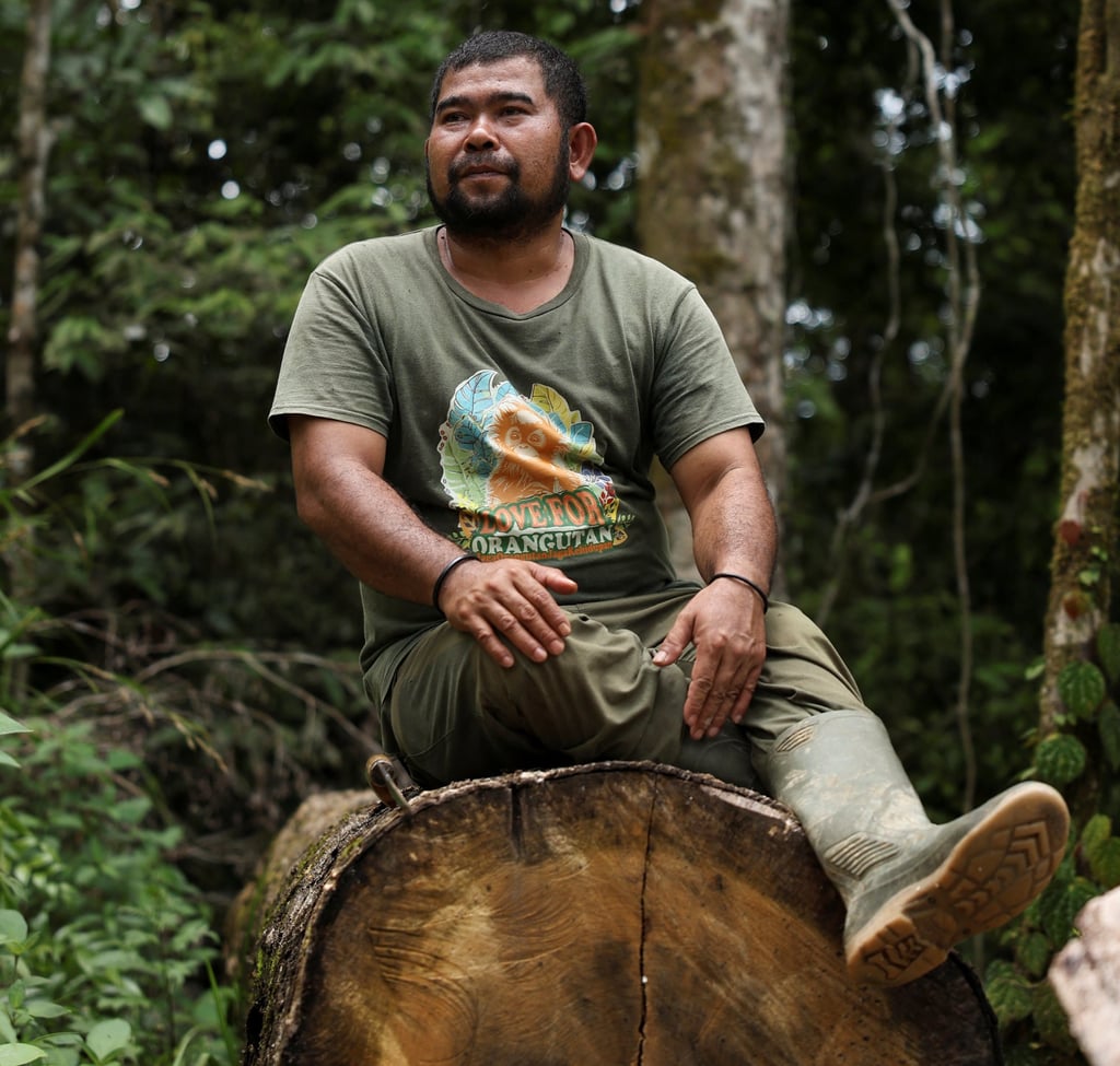 Siagian sits on a log he says is a remnant of illegal logging in the forests of Sipirok, North Sumatra province, on Monday. Photo: Reuters