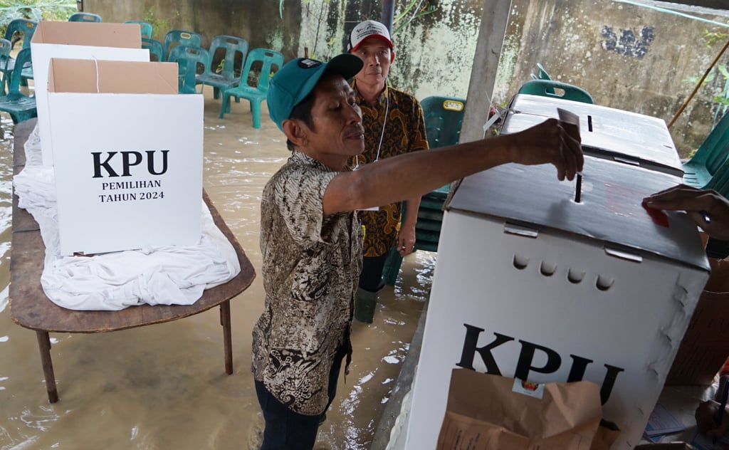 A man votes at a regional election despite the flood in Tanjung Gusta, North Sumatra, on November 27, 2024. Photo: Xinhua