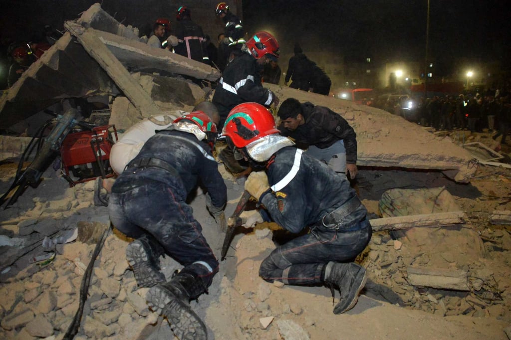 Emergency personnel search for victims in the rubble of a collapsed residential building late on Tuesday. Photo: AFP