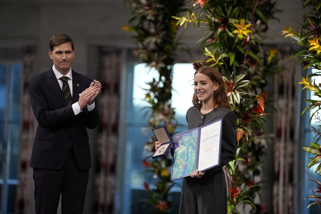 Ana Corina Sosa Machado (right), daughter of Nobel Peace Prize laureate Maria Corina Machado, accepts the award on behalf of her mother during an award ceremony on Tuesday. Photo: Reuters