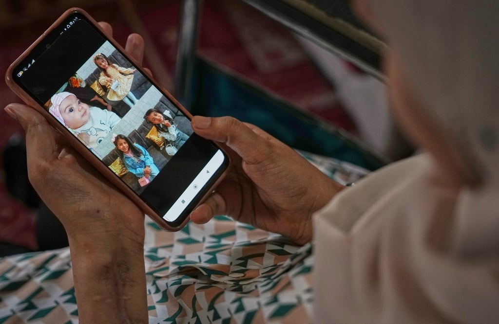 Haneen al-Mabhouh looks at photos of her daughters, all killed in an Israeli air strike, in her family home in Nuseirat, central Gaza Strip, on November 6. Photo: AP
