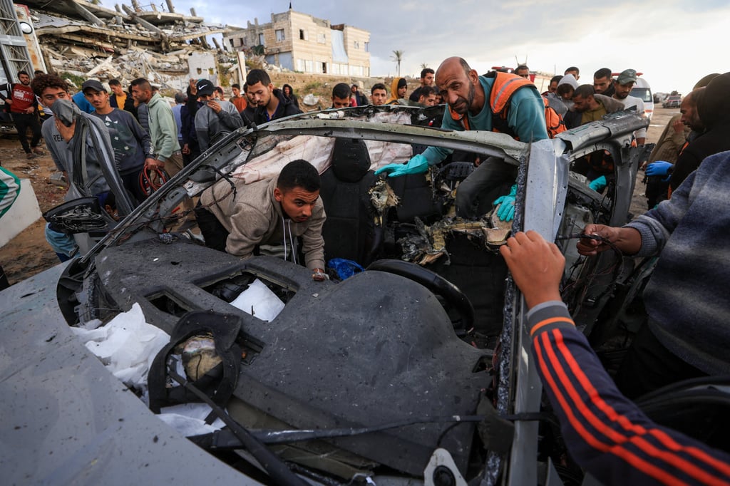 Palestinians inspect the site of an Israeli strike on a car in Gaza on Saturday. Photo: Reuters