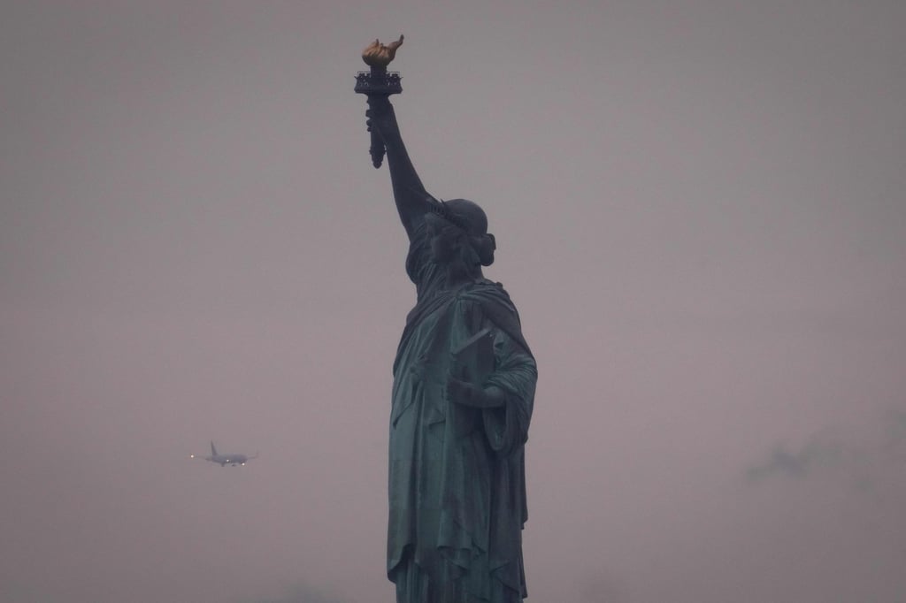 A plane prepares to land at Newark Liberty International Airport behind the Statue of Liberty in June. Photo: AFP