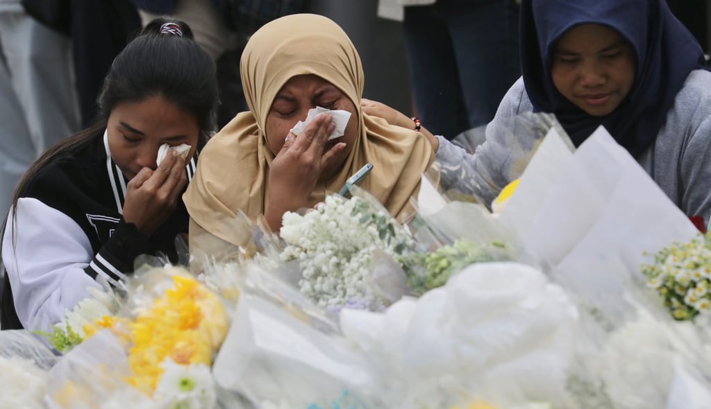 Indonesian women cry for their compatriots in front of a makeshift altar at the Wang Fuk Court fire disaster site on December 7. Photo: Zuma/dpa