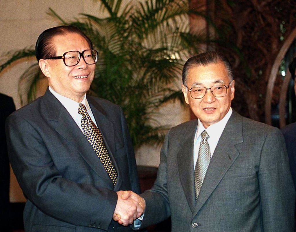Fuwa (right) shakes hands with Chinese President Jiang Zemin during a meeting in Beijing in 1998. Photo: AFP