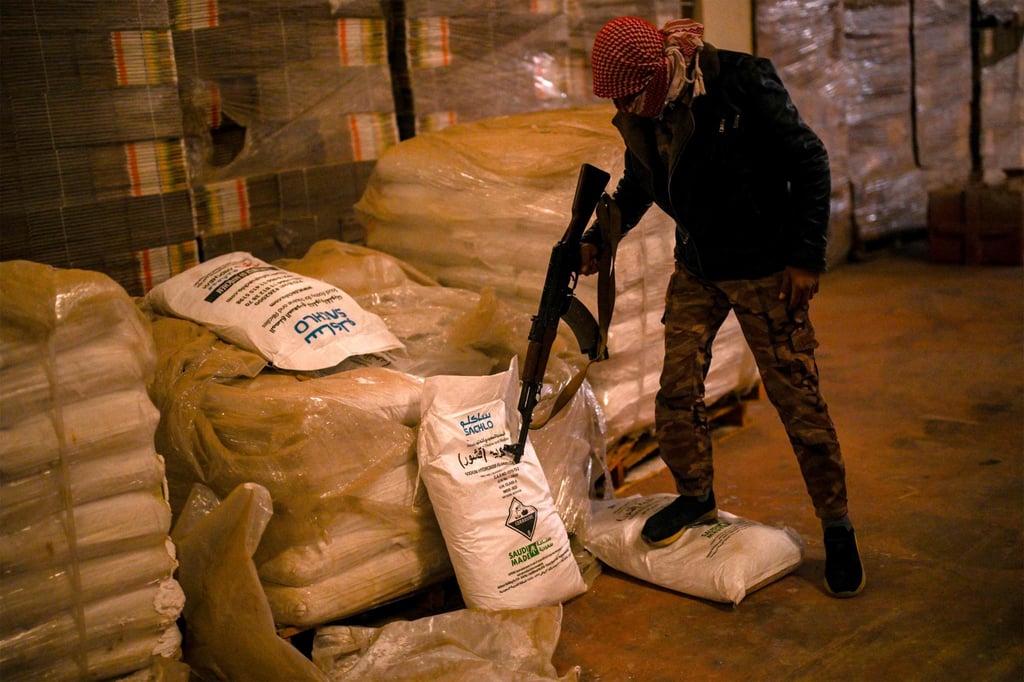 Syrian rebel fighters inspect sacks marked to contain “Saudi-made” flakes of caustic soda at a drug manufacturing facility in the city of Douma on the outskirts of Damascus in December 2024. Photo: AFP