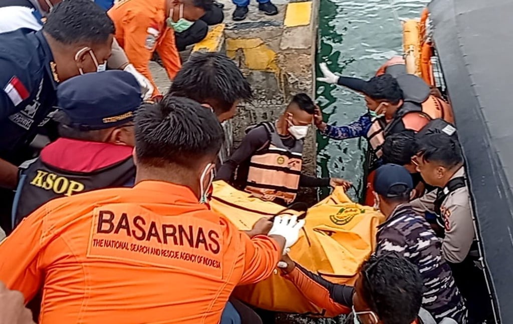 Indonesian rescuers lift the body of a victim onto the jetty at Labuan Bajo on Monday. Photo: EPA