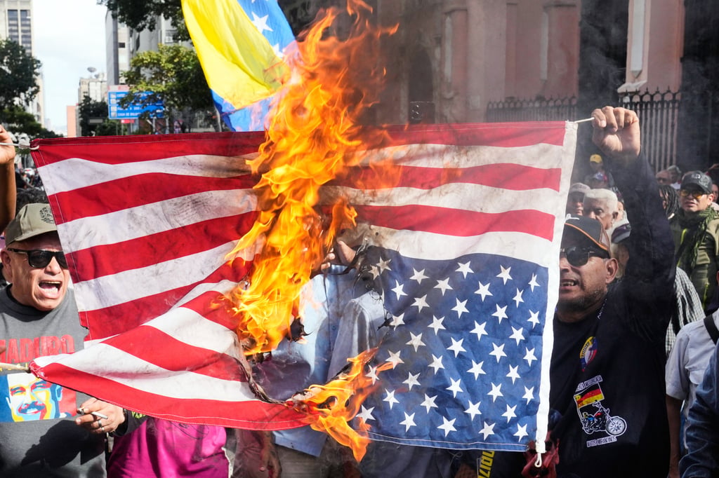 Government supporters burn a US. flag in Caracas, Venezuela, on Saturday. Photo: AP